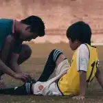 Agent de sécurité intervenant auprès d'un enfant sur le terrain d'un stade