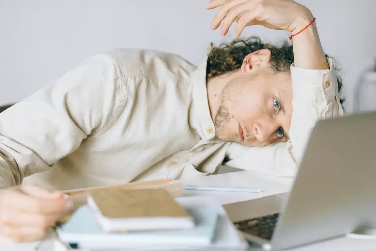 Personne fatiguée au bureau, illustrant les risques du non-usage des congés payés