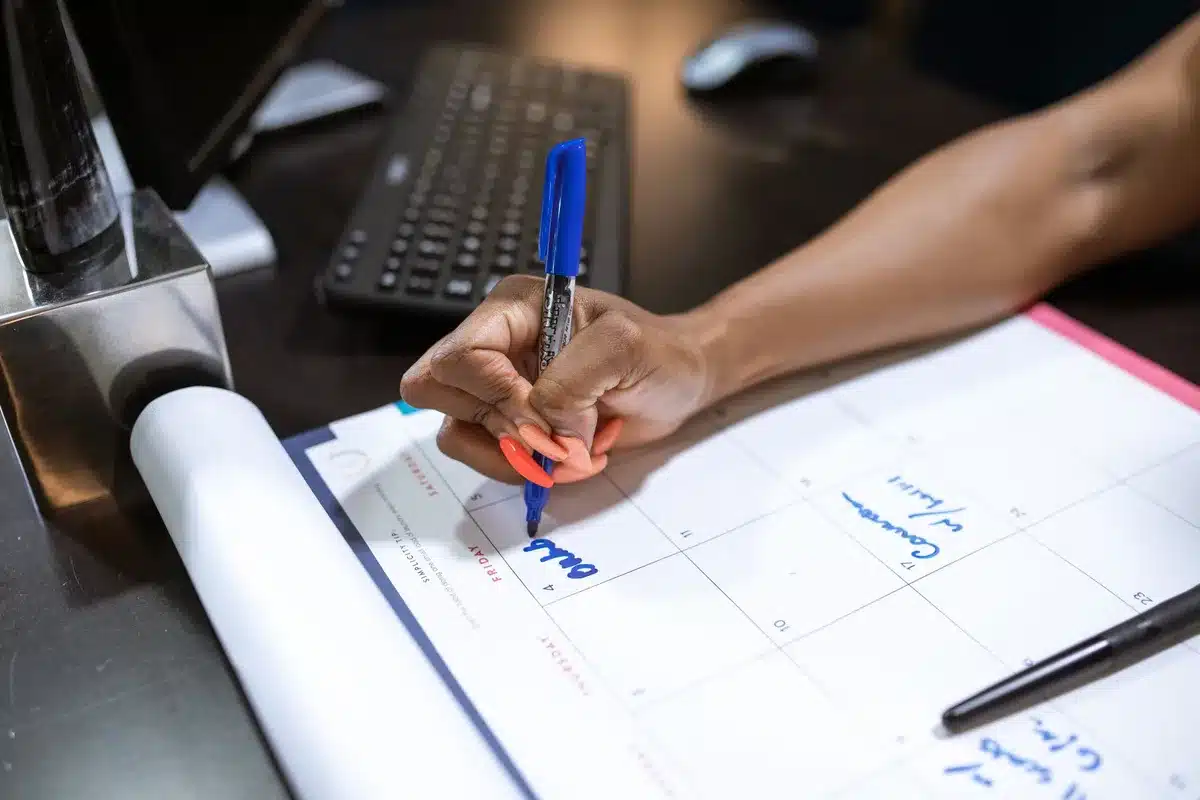 Bureau avec calendrier et brochures de voyage non utilisées, illustrant les congés payés non pris