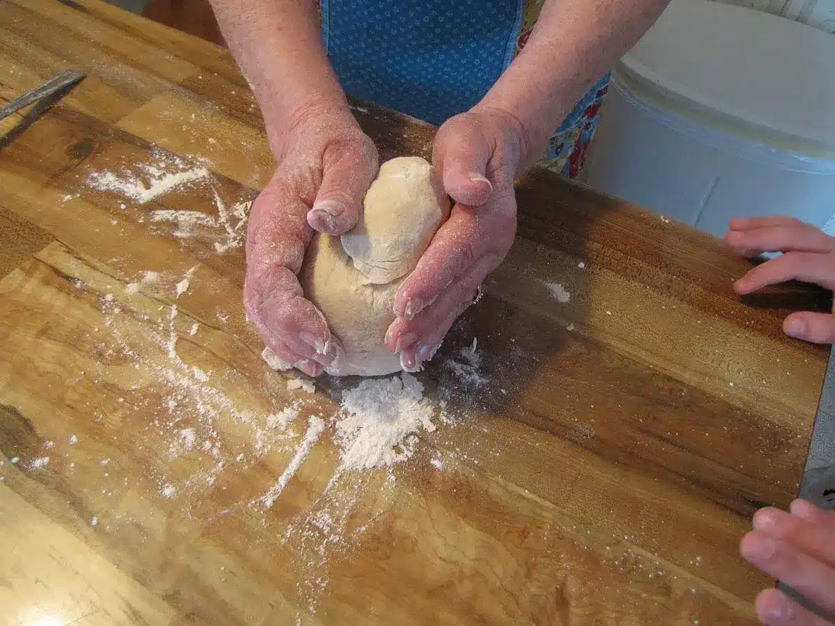 Un chef en cuisine jonglant entre préparation culinaire et responsabilités familiales