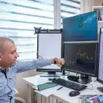 Bureau de trader avec écrans affichant des données boursières et des graphiques financiers