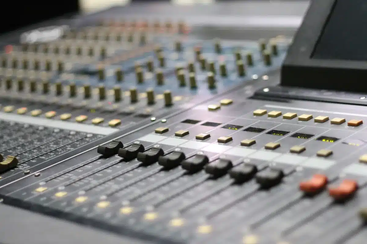 Studio de télévision moderne avec pupitre de présentation, écrans et équipe technique en arrière-plan