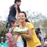 Parent et enfant marchant vers l'école, cartable sur le dos, lumière du matin