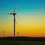 Silhouette industrielle au crépuscule avec éoliennes et usine en arrière-plan
