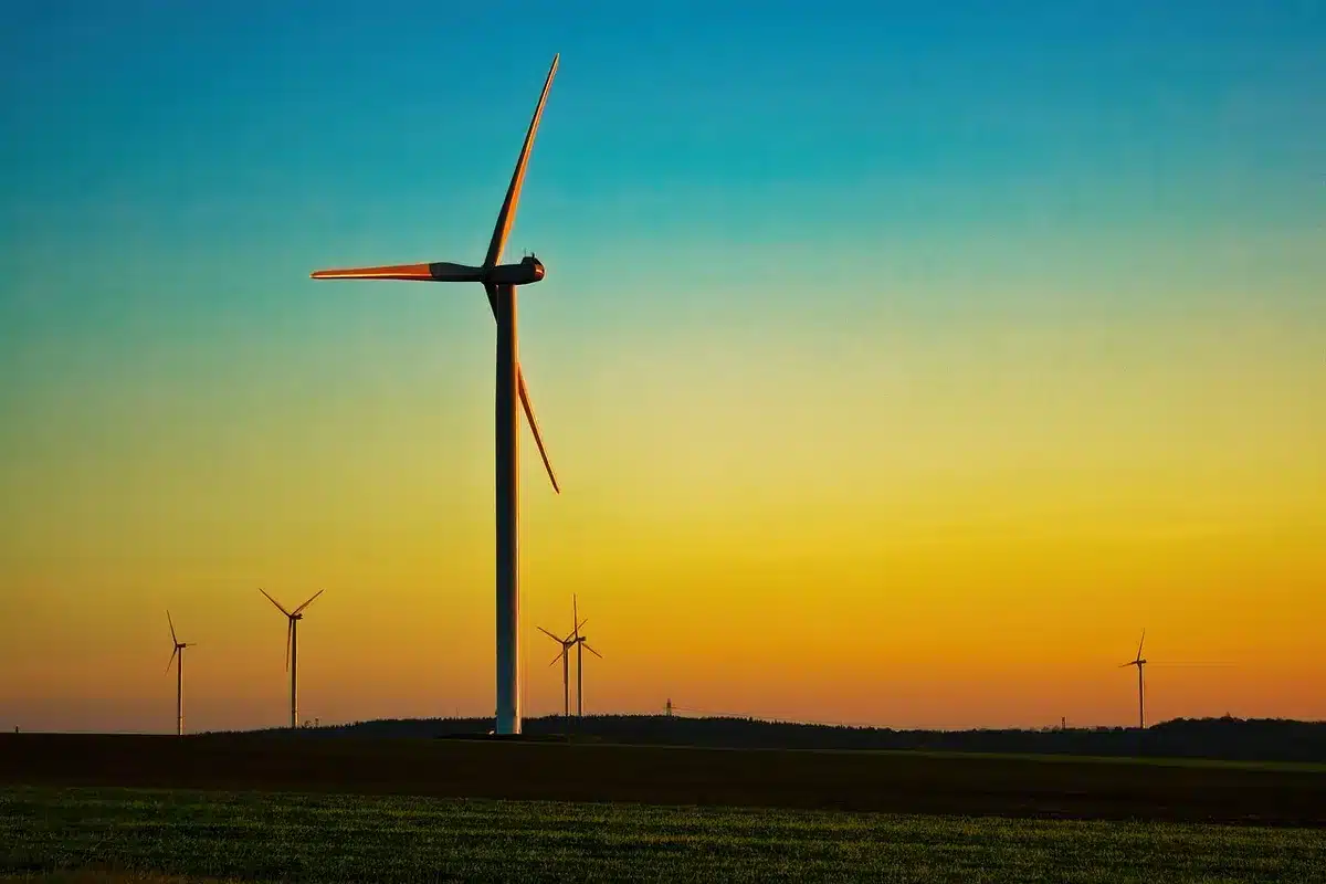 Silhouette industrielle au crépuscule avec éoliennes et usine en arrière-plan
