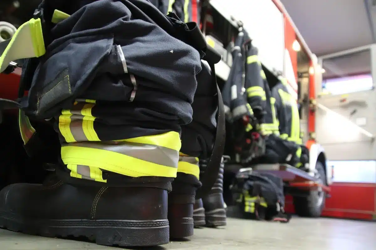 Équipes de pompiers et secours en intervention dans une zone forestière brûlée, contrôle de l'incendie en cours