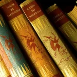 Pile de volumes de manga sur une étagère de librairie, avec des mains qui les saisissent