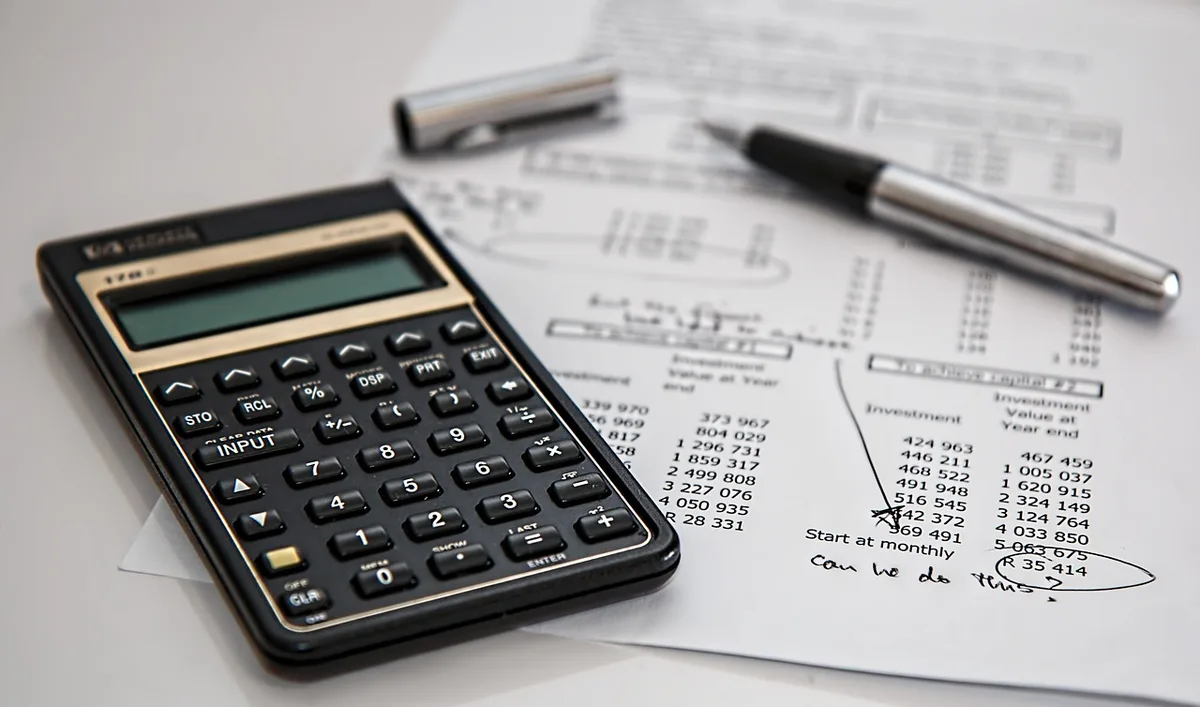 Documents de budget public et calculatrice illustrant le coût du service de la dette