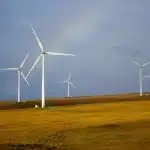 Silhouettes d'une éolienne et d'un lampadaire LED évoquant transition énergétique et investissement