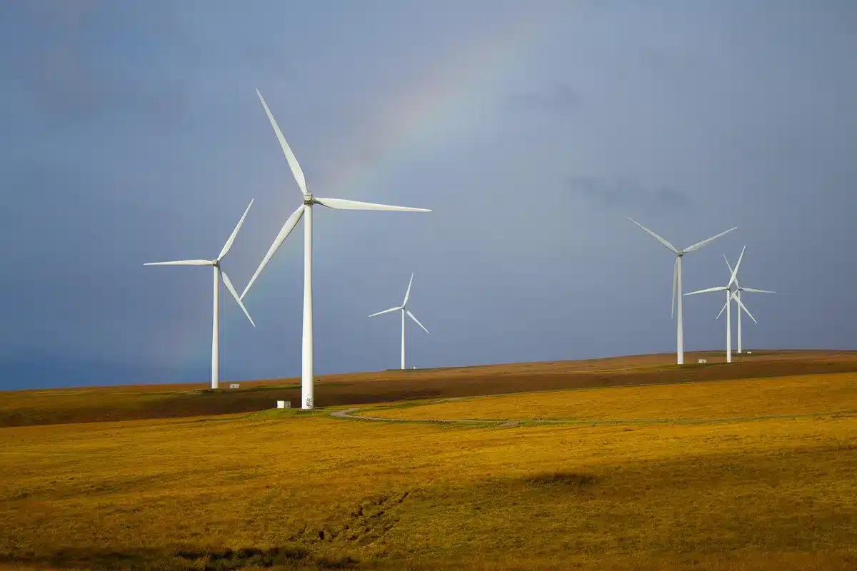 Silhouettes d'une éolienne et d'un lampadaire LED évoquant transition énergétique et investissement