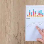 Table de réunion avec documents financiers et graphique obligataire, mains anonymes