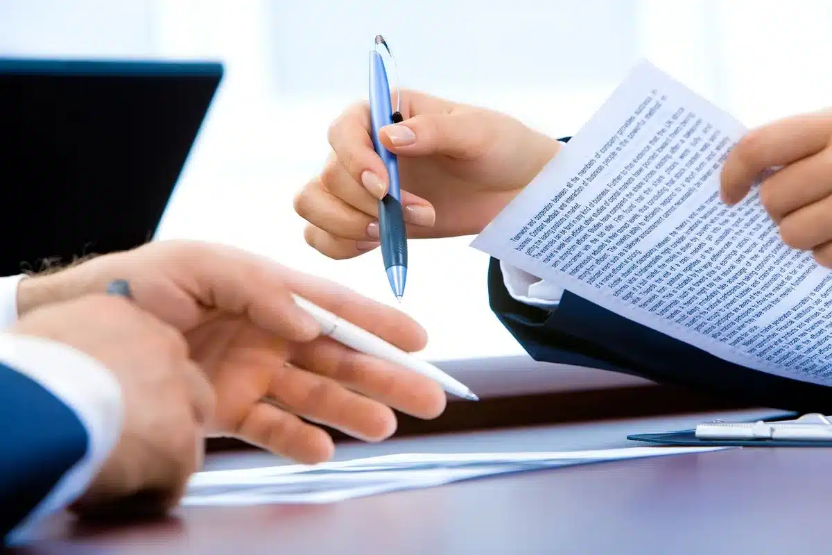 Mains anonymes tendant un document financier dans une salle de réunion