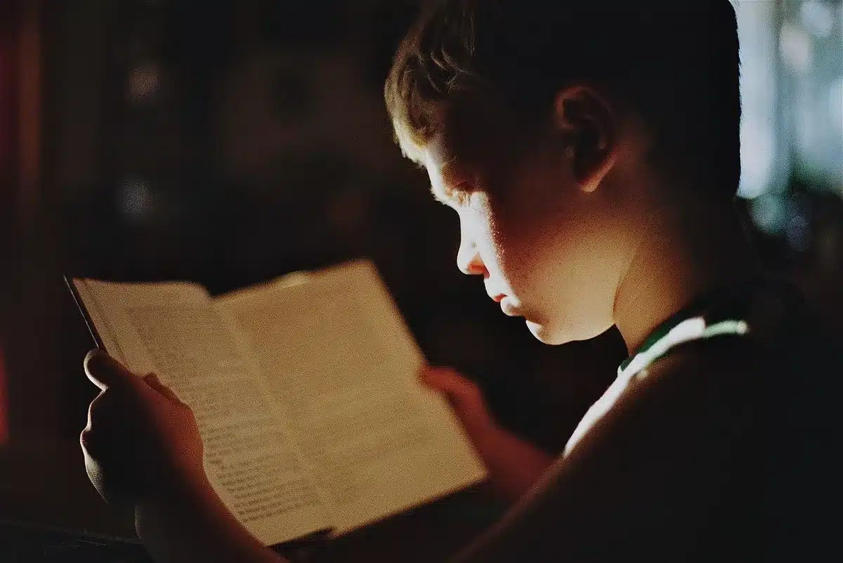 Enfants travaillant sous une lumière tamisée, montrant fatigue et difficulté de concentration