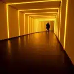 Intérieur d'un abri scolaire souterrain avec silhouettes d'enfants et piliers en béton